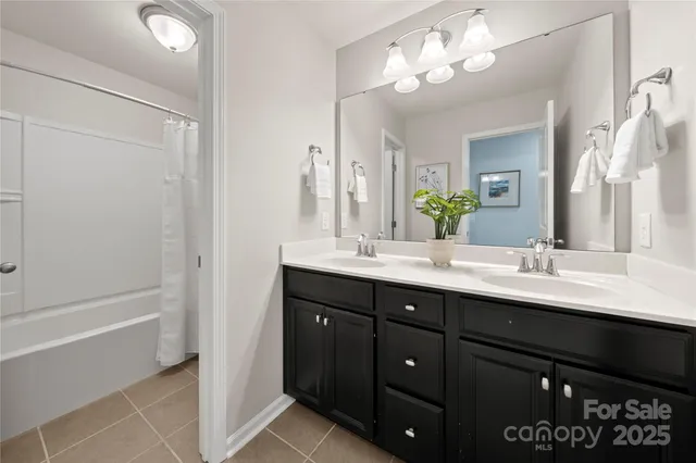 a bathroom with a sink double vanity granite tub and a mirror