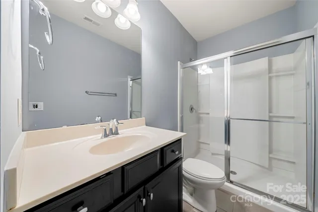 a bathroom with a sink a toilet a mirror and shower