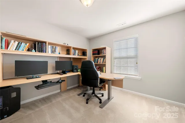 a view of a workspace with furniture and a window