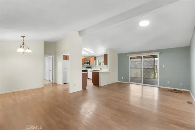 wooden floor in an empty room with a kitchen