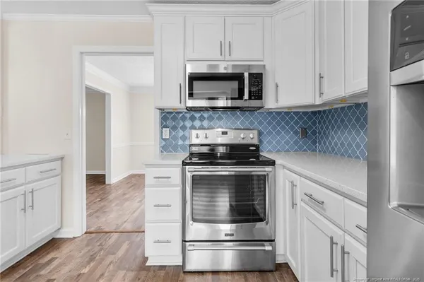 a kitchen with white cabinets and stainless steel appliances