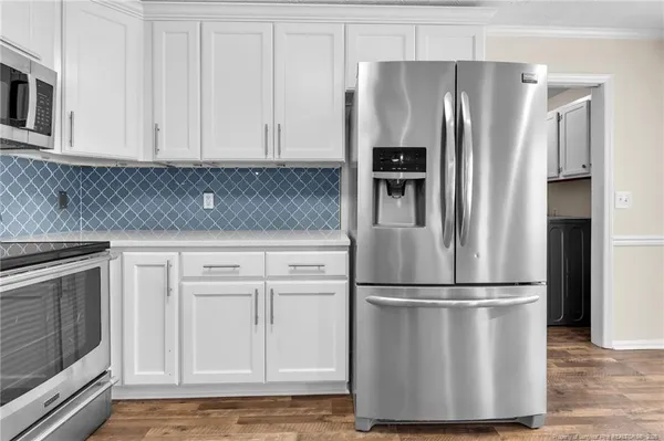 a kitchen with granite countertop stainless steel appliances and refrigerator