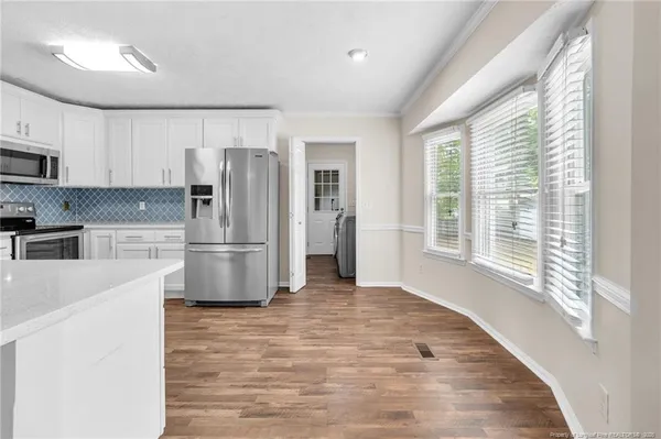 a kitchen with stainless steel appliances a refrigerator and a stove top oven