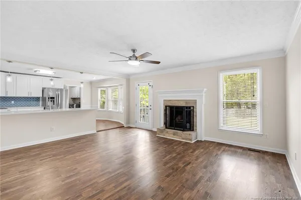 an empty room with wooden floor and a fireplace
