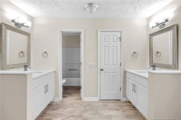 a spacious bathroom with a double vanity sink a mirror and a