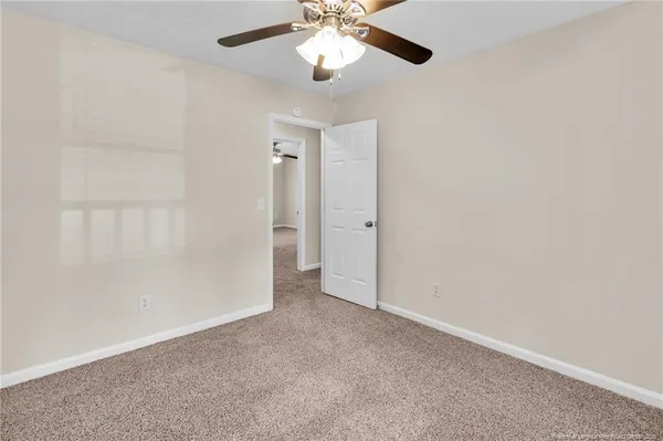 an empty room with chandelier fan