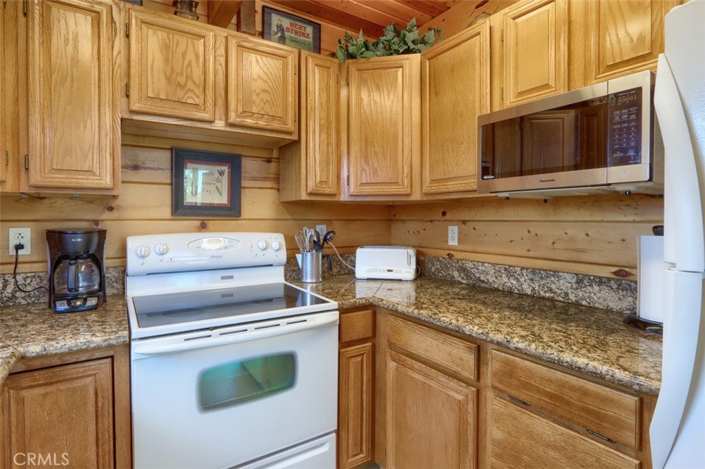 5027 Fox Creek Road Mariposa, CA 95338 - Photo 13 of 75 a kitchen with granite countertop a stove top oven microwave and cabinets
