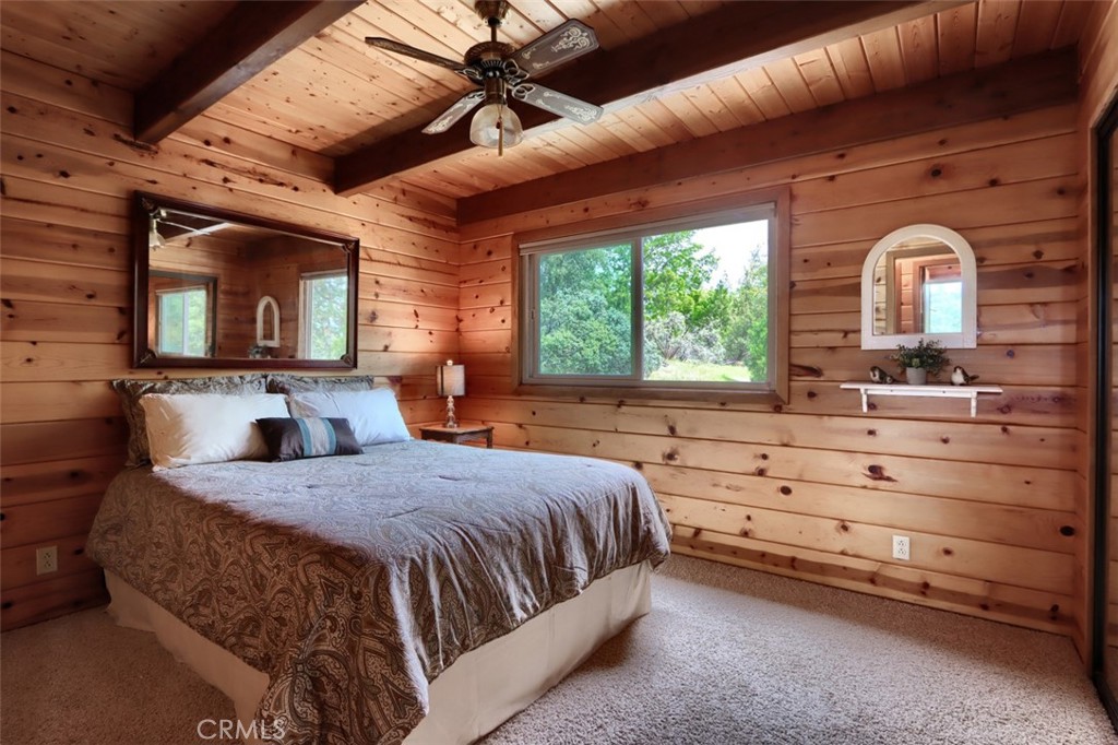5027 Fox Creek Road Mariposa, CA 95338 - Photo 18 of 75 a bedroom with a bed a chandelier and a flat tv screen