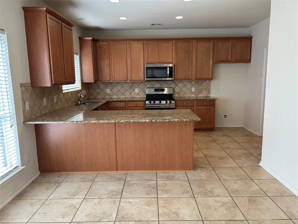 a kitchen with a sink a stove top oven and cabinets