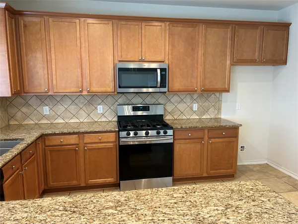 a kitchen with granite countertop a sink and a stove