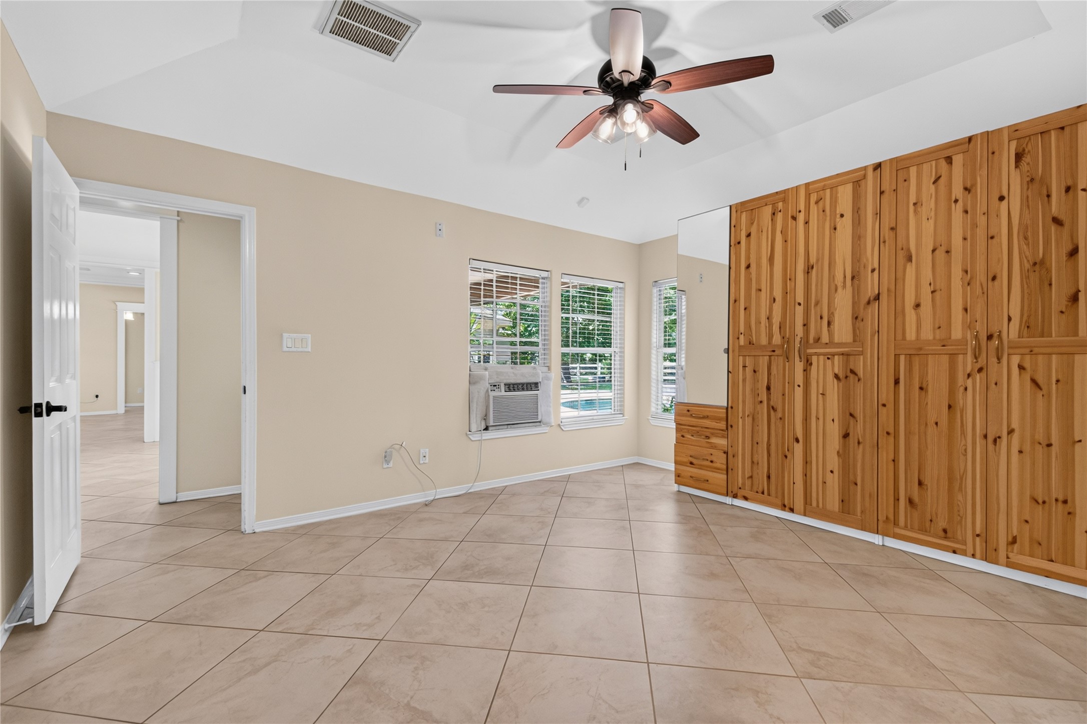 20203 Timber Ridge Drive Magnolia, TX 77355 - Photo 28 of 49 Spacious primary suite with abundant natural light and durable tile flooring throughout. A wall of custom built-in wood wardrobes provides exceptional storage and organization