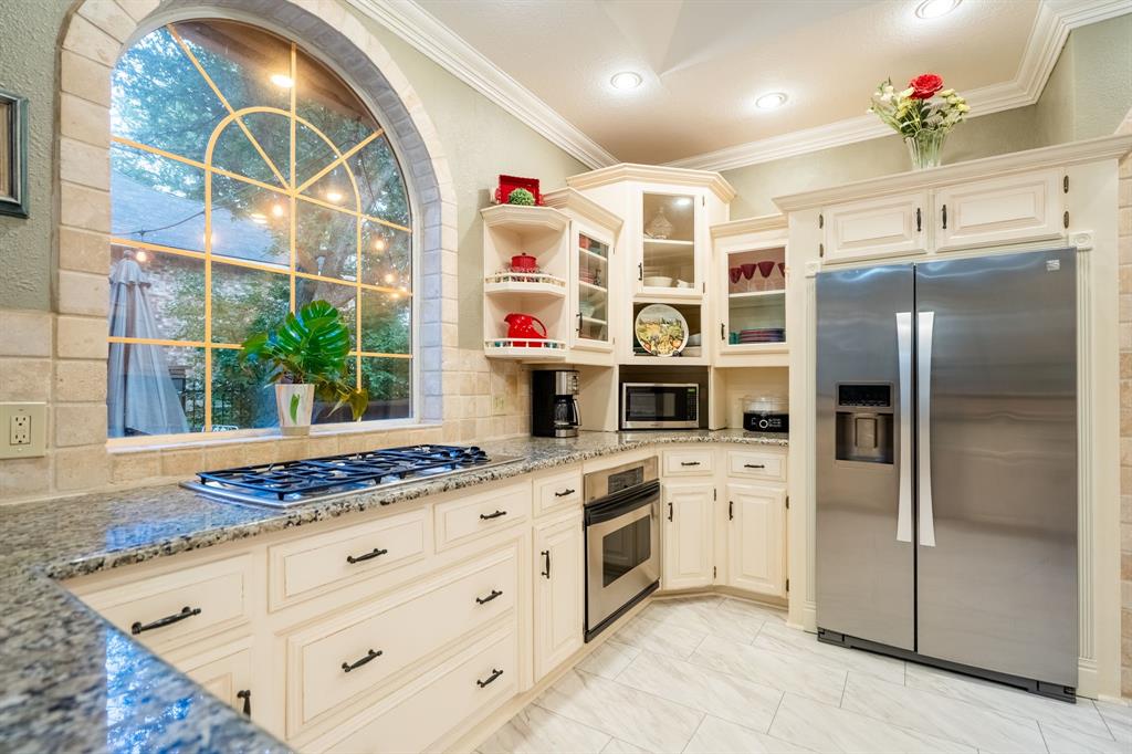 1450 Meandering Way Rockwall, TX 75087 - Photo 12 of 32 a kitchen with stainless steel appliances granite countertop a refrigerator and a sink