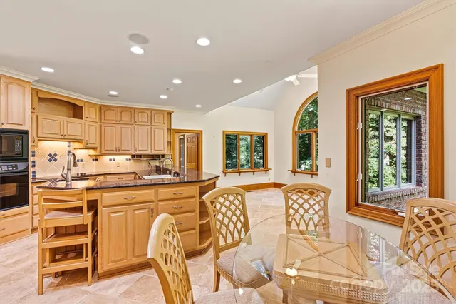 a large kitchen with stainless steel appliances granite countertop a large window and a counter space