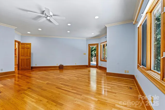 a view of an empty room with window and wooden floor