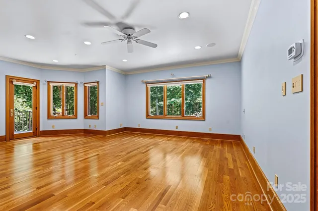 an empty room with window and ceiling fan