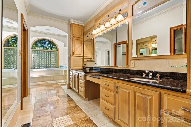 a large kitchen with stainless steel appliances a stove a sink and a large window