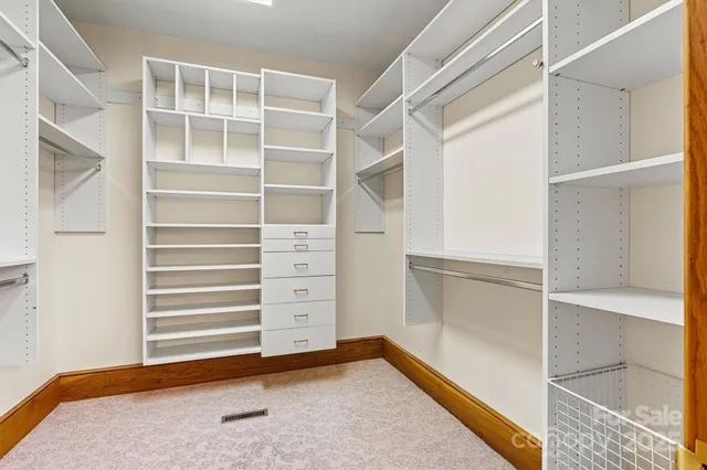 a view of an empty room with cabinet and a window