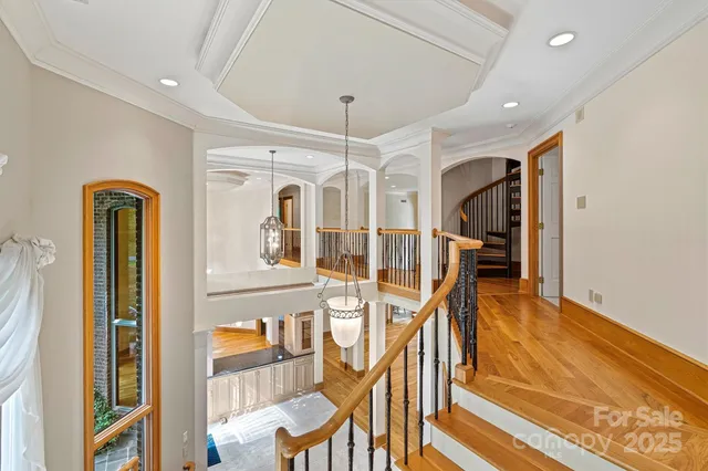 a view of a hallway with furniture and chandelier
