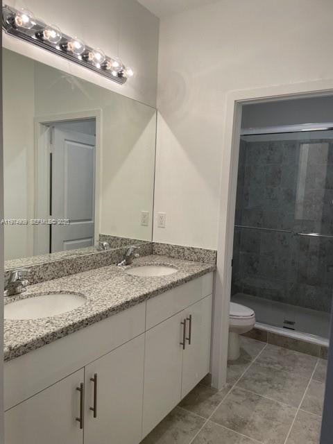 25308 Southwest 135th Avenue Homestead, FL 33032 - Photo 11 of 25 a bathroom with a granite countertop sink a toilet and a shower