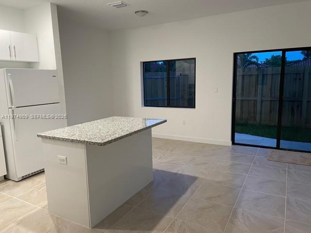 25308 Southwest 135th Avenue Homestead, FL 33032 - Photo 22 of 25 a kitchen with granite countertop a sink and a stove