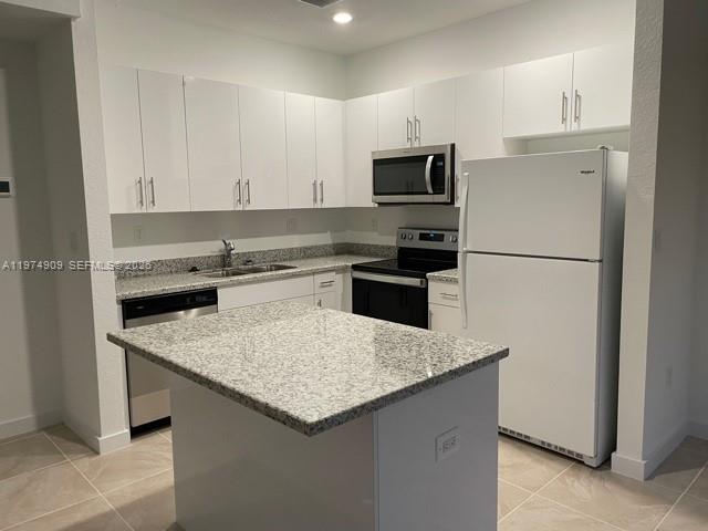 25308 Southwest 135th Avenue Homestead, FL 33032 - Photo 23 of 25 a kitchen with a sink a stove a refrigerator and white cabinets