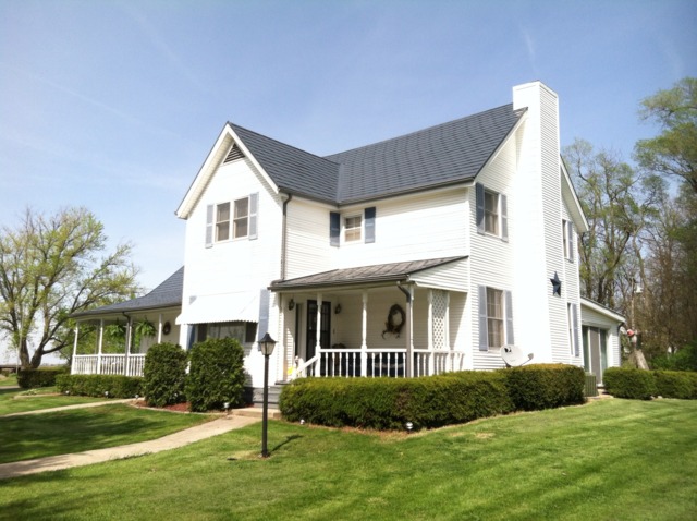 18442 East Twombly Road Rochelle, IL 61068 - Photo 1 of 20 a view of a white house next to a yard with big trees