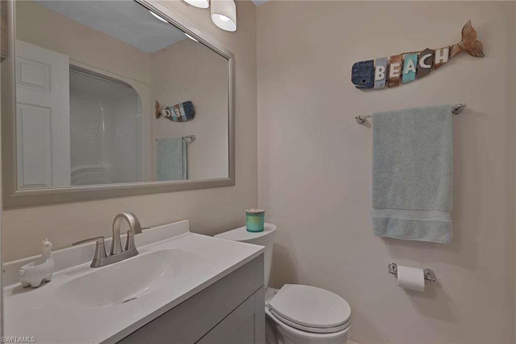 379 Gabriel Circle, Unit 2304 Naples, FL 34104 - Photo 12 of 23 a bathroom with a sink a toilet and mirror