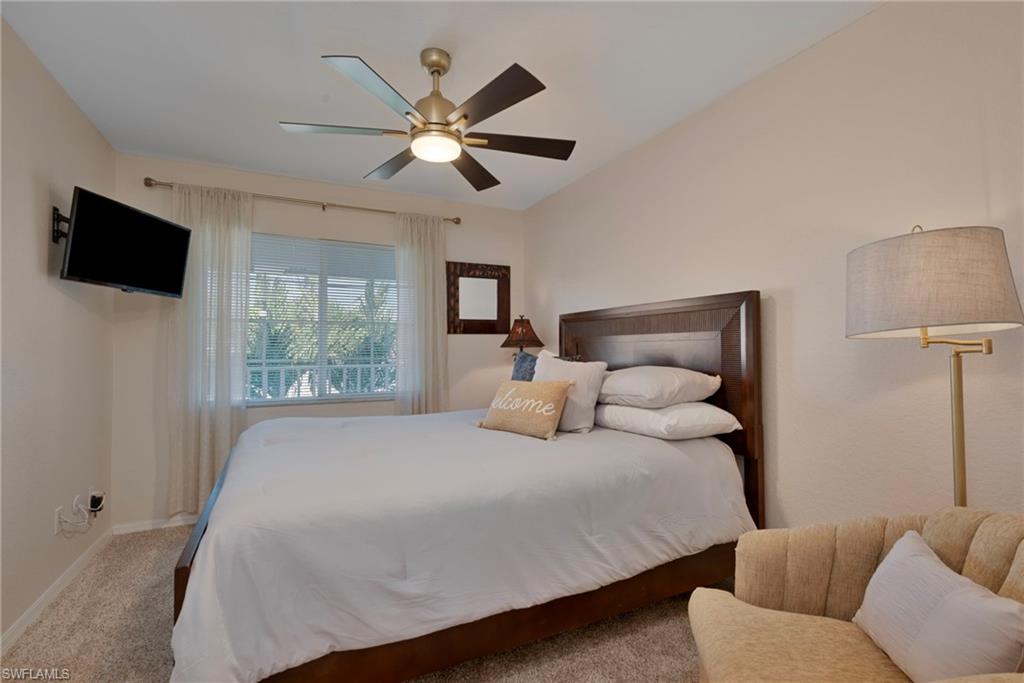 379 Gabriel Circle, Unit 2304 Naples, FL 34104 - Photo 13 of 23 a bedroom with a large bed and a flat screen tv