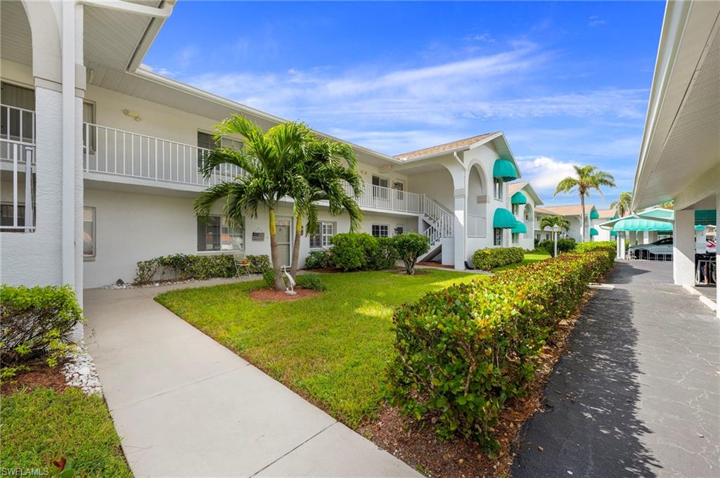 379 Gabriel Circle, Unit 2304 Naples, FL 34104 - Photo 15 of 23 a front view of a house with garden