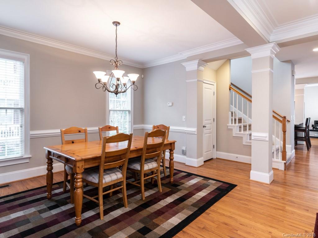 1148 Market Street Fort Mill, SC 29708 - Photo 15 of 25 a dining room with wooden floor a chandelier a wooden table and chairs