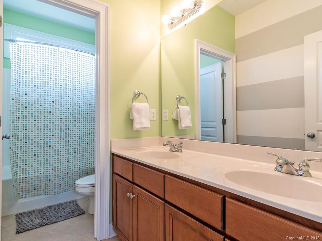 1148 Market Street Fort Mill, SC 29708 - Photo 21 of 25 a bathroom with a granite countertop sink a toilet and shower