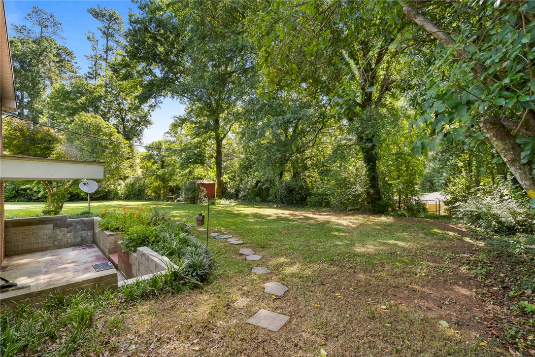 512 East Fredericks Street Anderson, SC 29621 - Photo 26 of 31 A spacious backyard retreat features a private patio, lush landscaping, and mature trees, creating an ideal outdoor living space.