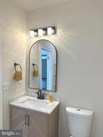 a bathroom with a toilet sink and mirror