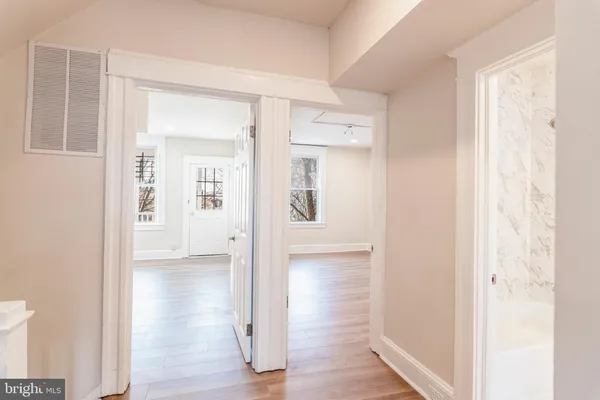 a view of a hallway with wooden floor and closet