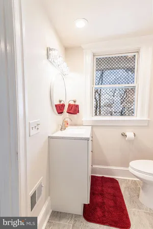 a bathroom with a sink toilet vanity and window
