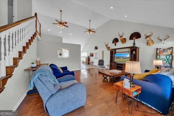 a living room with furniture kitchen view and a wooden floor
