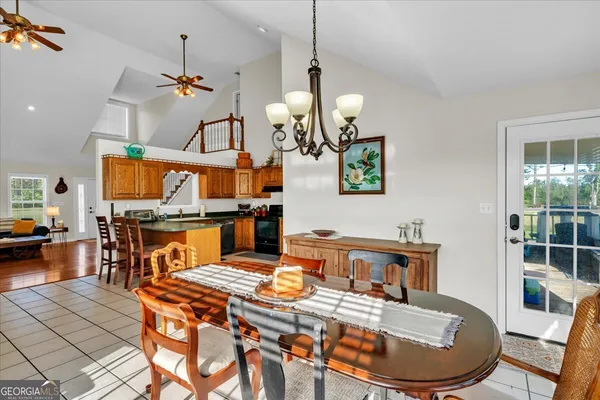 a dining room with wooden floor a chandelier a wooden table and chairs