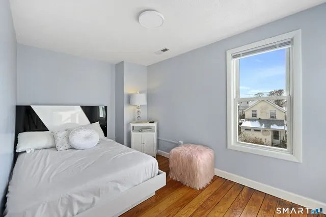 a view of a livingroom with wooden floor and a flat screen tv