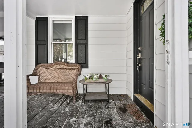 a balcony with table and chairs and wooden floor