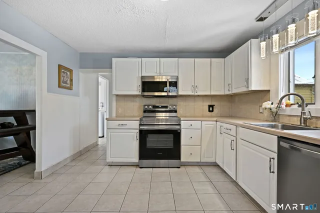 a kitchen with cabinets stainless steel appliances and a counter space