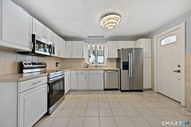 a kitchen with a white cabinets and white appliances