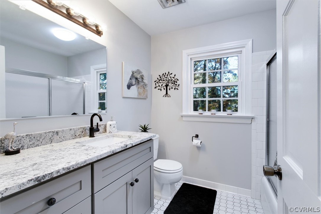 3670 Hemlock Road Chester, VA 23831 - Photo 33 of 49 a bathroom with a granite countertop sink a toilet and a window