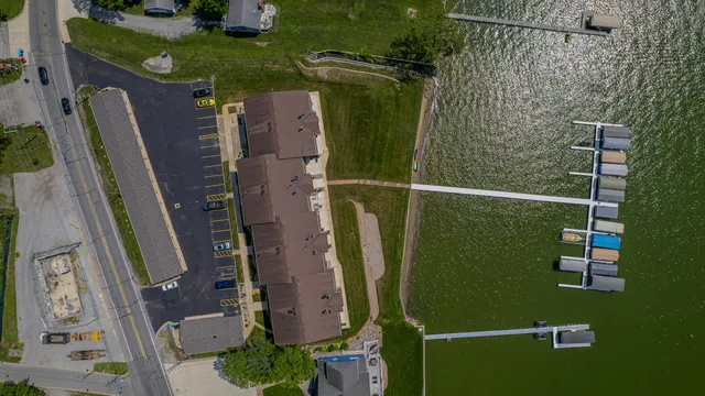an aerial view of a residential houses with outdoor space and parking