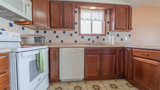 a kitchen with stainless steel appliances granite countertop a sink stove and cabinets