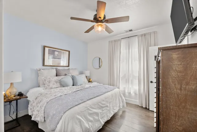 a bedroom with a bed and wooden floor