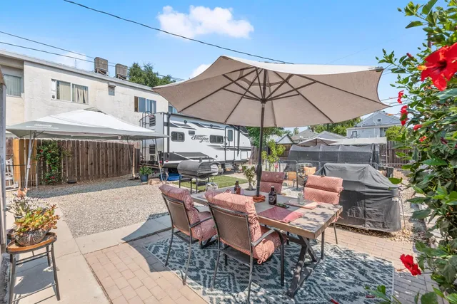 a patio with a table and chairs under an umbrella
