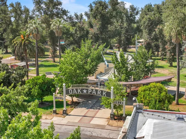 a view of a white building among the street with palm trees