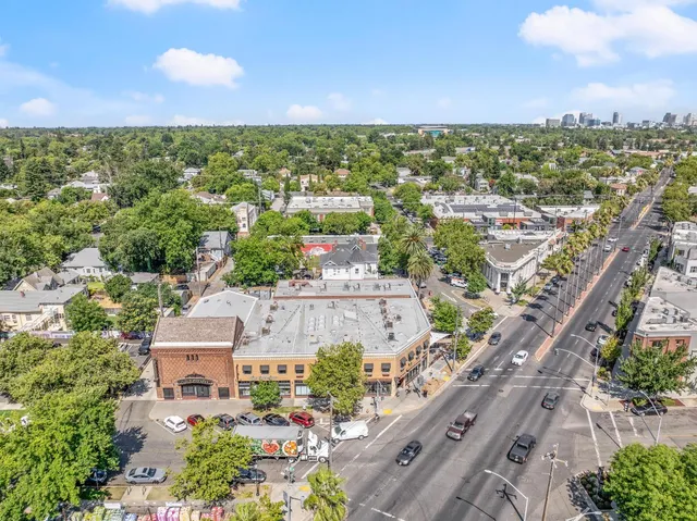 an aerial view of residential houses with outdoor space and trees