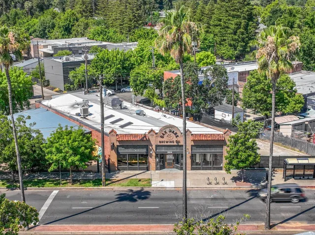 an aerial view of residential house with outdoor space and trees all around