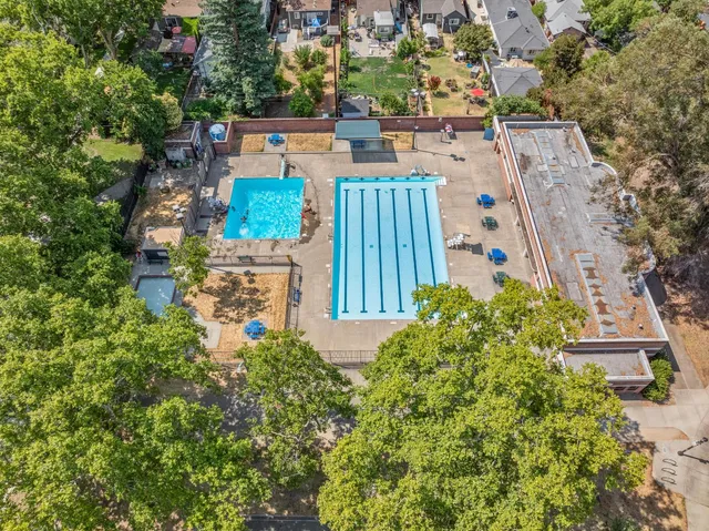 an aerial view of a city with lots of residential buildings ocean and mountain view in back